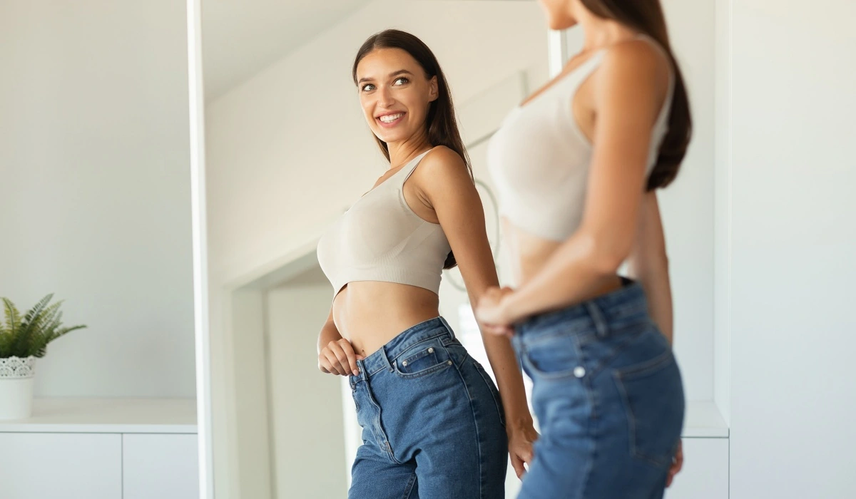 Woman admiring herself in the mirror after weight loss with semaglutide